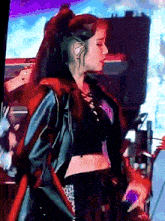 a woman wearing a black crop top and a black jacket