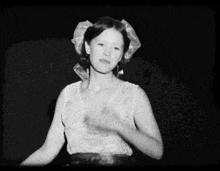 a black and white photo of a woman dancing in a dress .