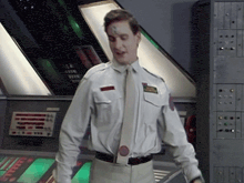 a man wearing a white shirt and tie has a patch on his chest that says ' a.m. '