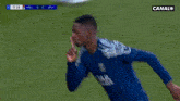 a soccer player is blowing a kiss while wearing a blue shirt that says jak