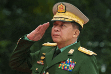 a man in a military uniform salutes while wearing a gold hat