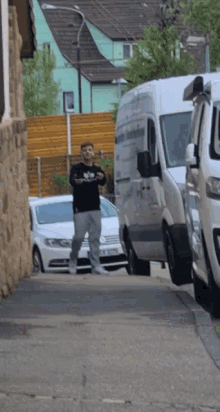 a man standing on a sidewalk next to a white van with the word volkswagen on it