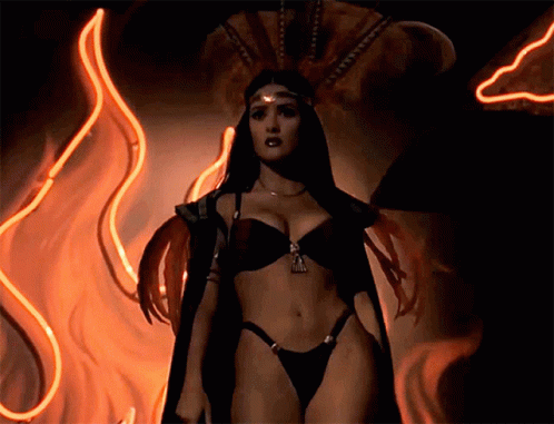 a woman in a bikini is standing in front of fire