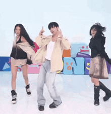 a man and two women are dancing in front of a sign that says on