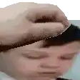a close up of a person 's face with a hand holding their head .