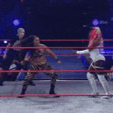 a female referee watches two women wrestle in a ring that says transglow on the bottom