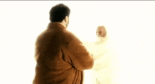 a man and a woman are standing next to each other in a room .