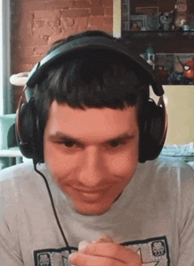 a man wearing headphones and a shirt with a skull on it looks at the camera