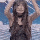 a woman is dancing on a stage with her hands in the air .