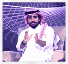 a man with a beard is sitting in a chair with his hands out