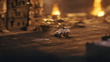 a toy car is driving down a destroyed city street