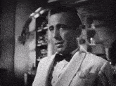 a black and white photo of a man in a suit and bow tie