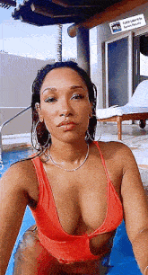 a woman in a red bikini is taking a selfie in a swimming pool