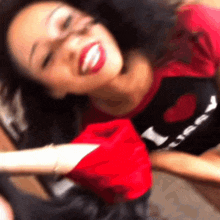 a woman wearing a shirt that says i love you is smiling