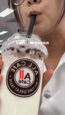 a woman drinking a milkshake with a straw from a cup that says jia on it