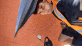 a man is sitting on a scooter with an umbrella on his head