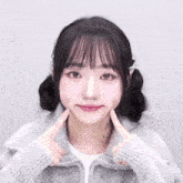 a girl with pigtails is making a face with her fingers