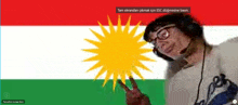 a man giving a peace sign in front of a flag that says tam ekrandan