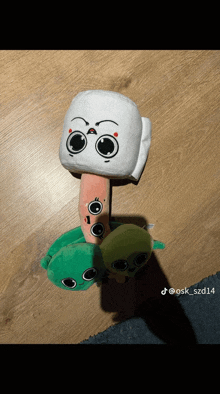 three stuffed animals are stacked on top of each other on a wooden table