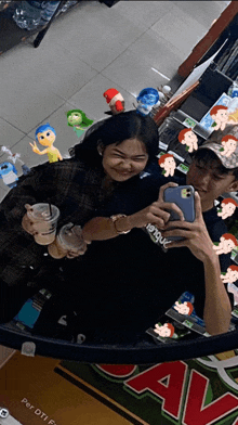 a man and a woman are taking a selfie in front of a sign that says ava
