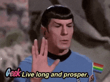 a man in a blue shirt is holding a rainbow flag and says " geek live long and prosper "