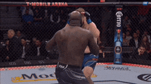 two men are fighting in a boxing ring in front of a corona ad