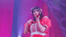 a young woman in a red dress is standing on a stage .