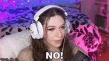 a woman wearing headphones is sitting in front of a microphone and saying `` no '' .