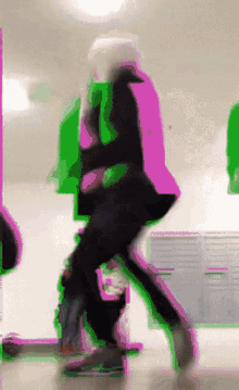 a person is walking down a hallway with a green and pink background .