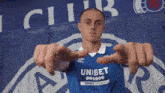 a man wearing a blue shirt with the word unibet on the front