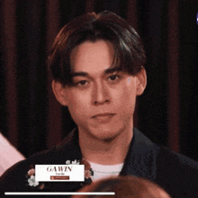a young man is making a funny face in front of a group of people .