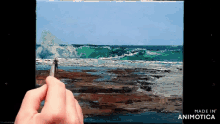 a person is painting a picture of the ocean with the words made in animotica on the bottom right