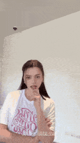 a woman wearing a white t-shirt that says hooduserie on it