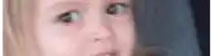 a close up of a young girl 's face with a blurry background .