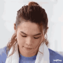 a young man with long hair and a towel around his neck is making a face .