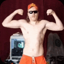 a shirtless man wearing sunglasses and a hat is flexing his muscles in a room .