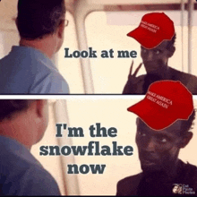 a man wearing a make america great again hat looks at himself in a mirror .