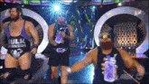 three wrestlers are on a stage and one of them is wearing a purple tank top that says hulk ronson