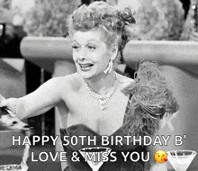 a black and white photo of a woman sitting at a table with a martini and a birthday message .