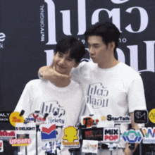 two men standing next to each other with one wearing a t-shirt that says " wetv original "