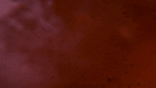 a silhouette of a person standing in a red foggy area