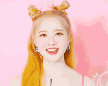 a woman with blonde hair is wearing a pink top and earrings