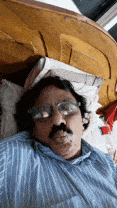 a man wearing glasses is laying on a bed