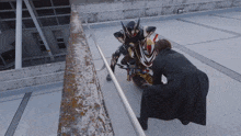 a man in a black coat is kneeling down next to a motorcycle