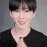 a close up of a young man wearing a black shirt .