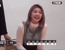 a woman is sitting on a chair and smiling while a person holds her hand .