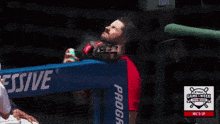 a man spraying something on his face in front of a sign that says game week