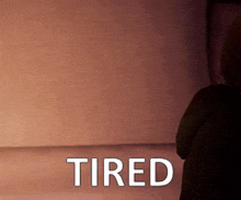 a person sitting in a room with the word tired on the floor