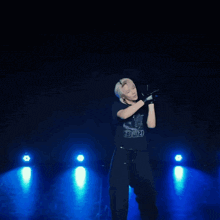 a man wearing a black shirt with a skeleton on it holds a microphone