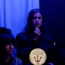 a woman in a dark room with a sign that says imp on it